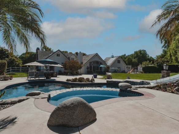 a pool surrounded by palm trees and landscaping